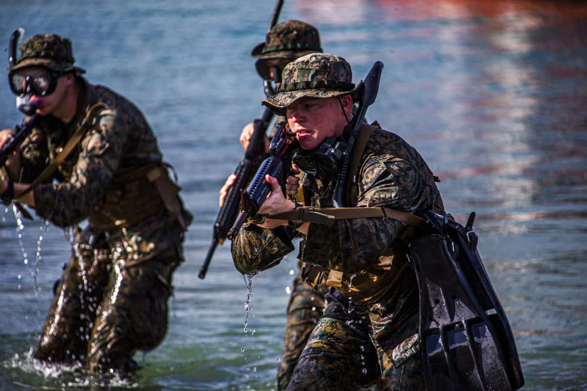Marines In Camouflage Walking Through Water Wallpaper