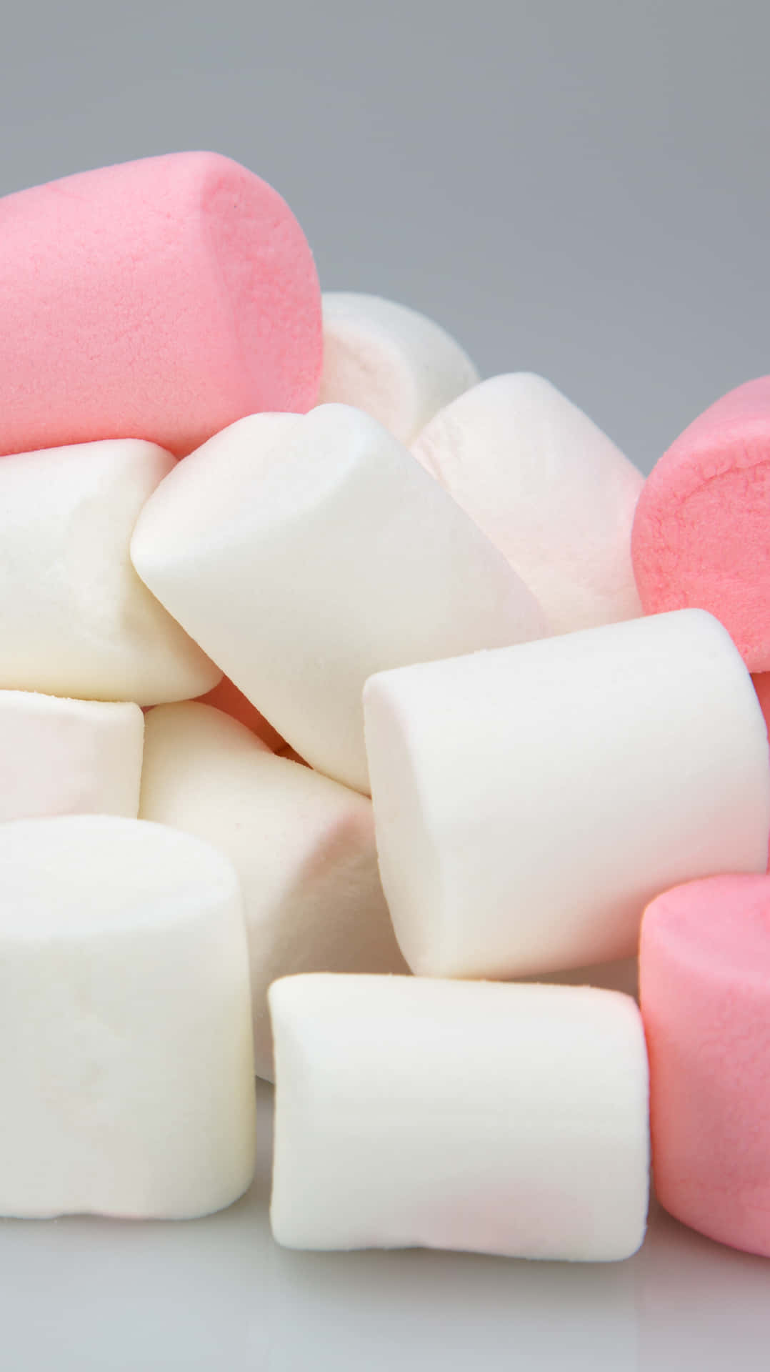 En bunke af pink og hvide marshmallows på en grå baggrund Wallpaper