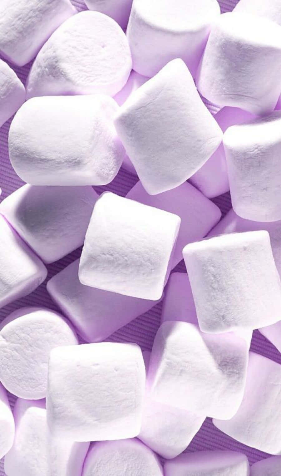 A Pile Of White Marshmallows On A Purple Background