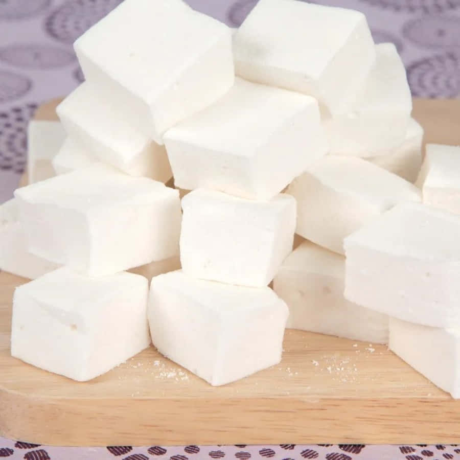 A Pile Of White Marshmallows On A Cutting Board