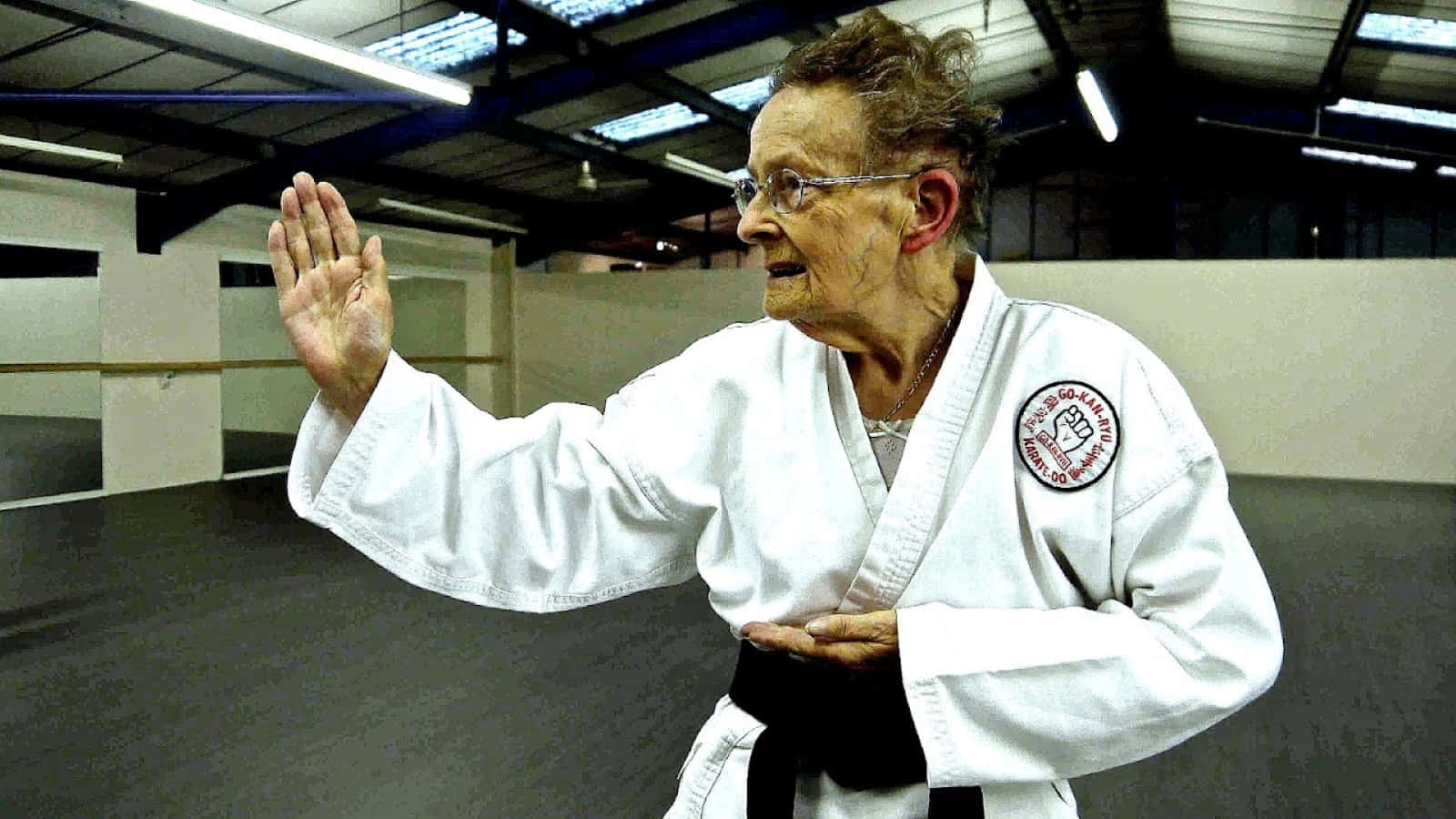 A martial artist wearing a white uniform performing a high kick Wallpaper