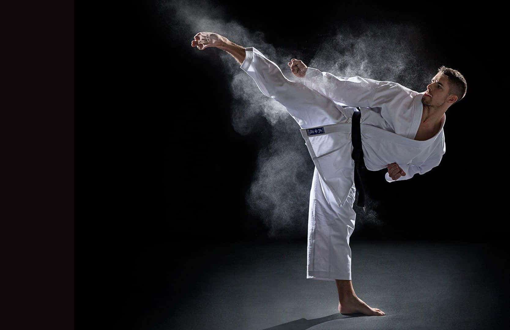 Martial artist striking a pose in traditional uniform Wallpaper