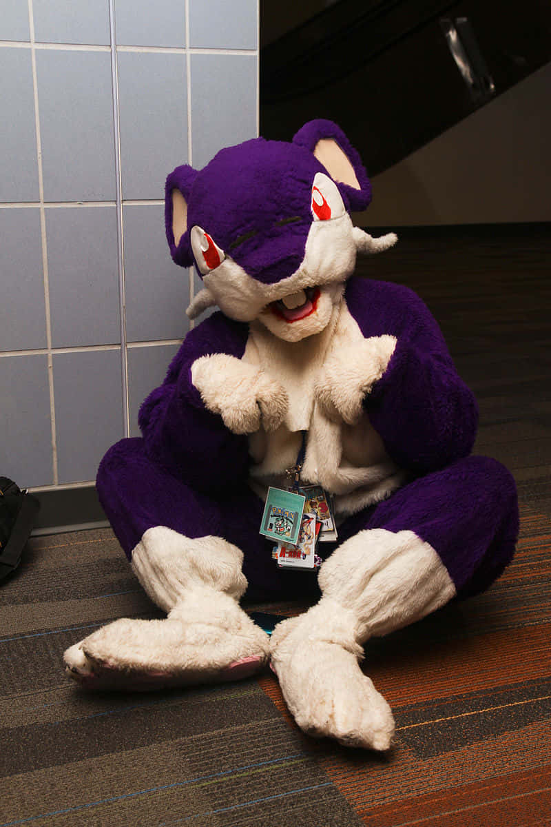 Mascot Costume Of Pokemon Rattata Sitting On A Floor Wallpaper