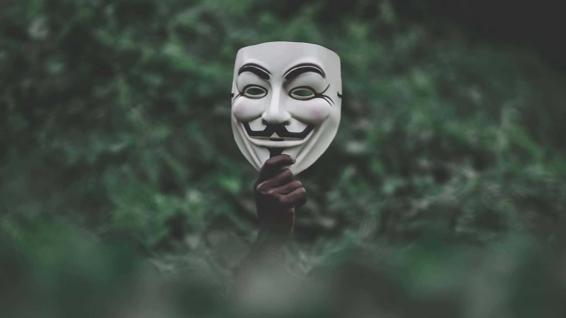A Person Holding A Mask With A V For Vendetta