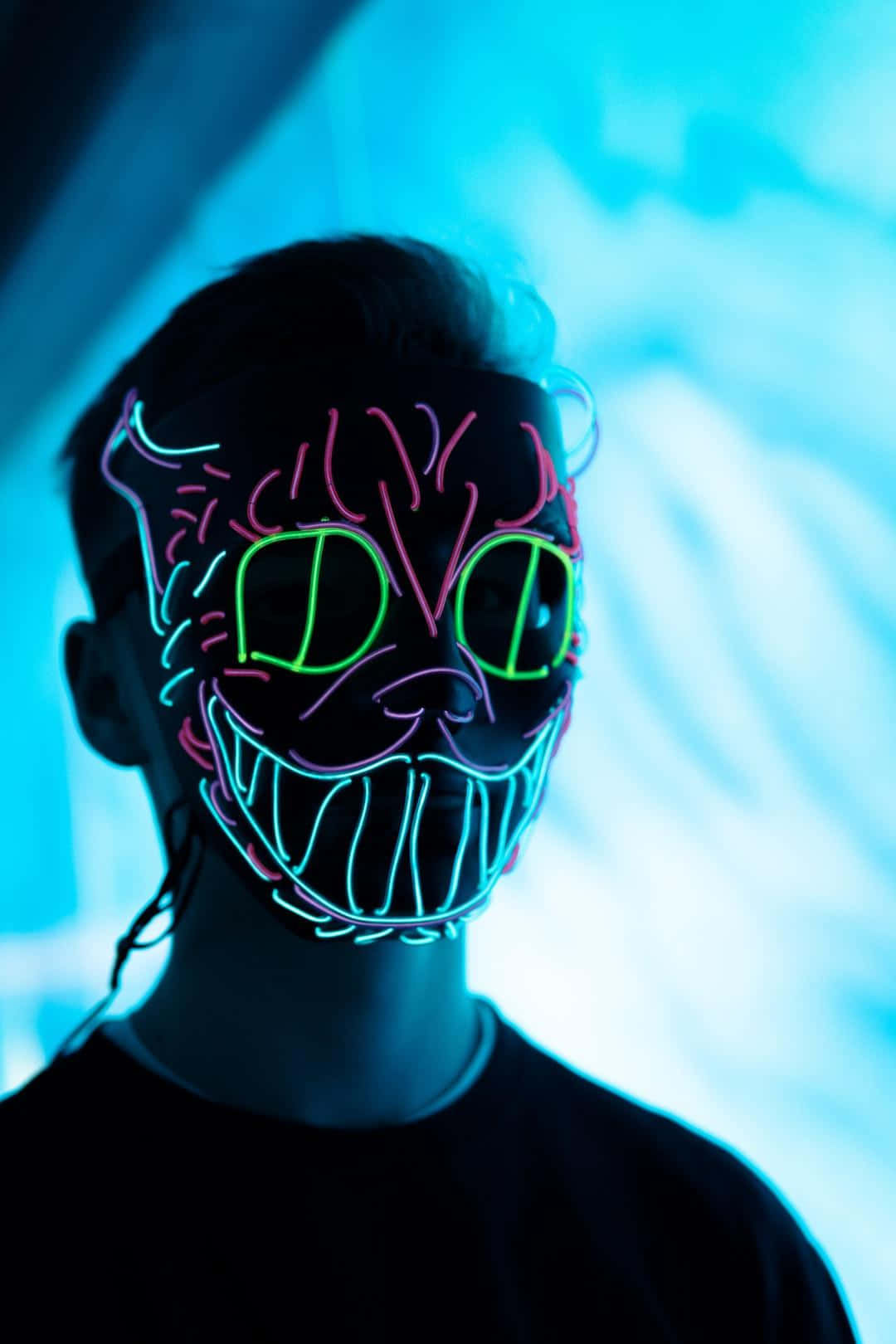 A Man Wearing A Neon Cat Mask