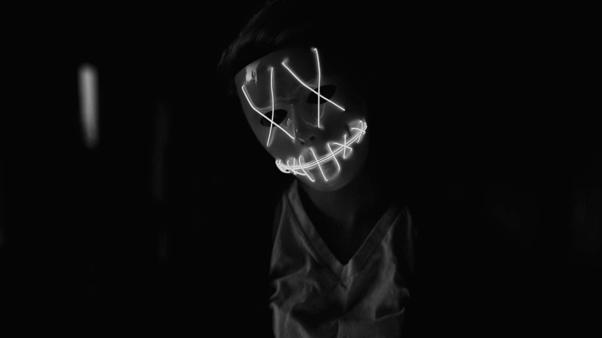 A Person With A Glowing Mask In The Dark