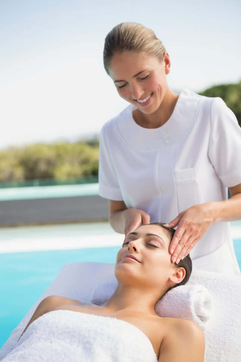 A Woman Getting A Facial Massage At A Spa