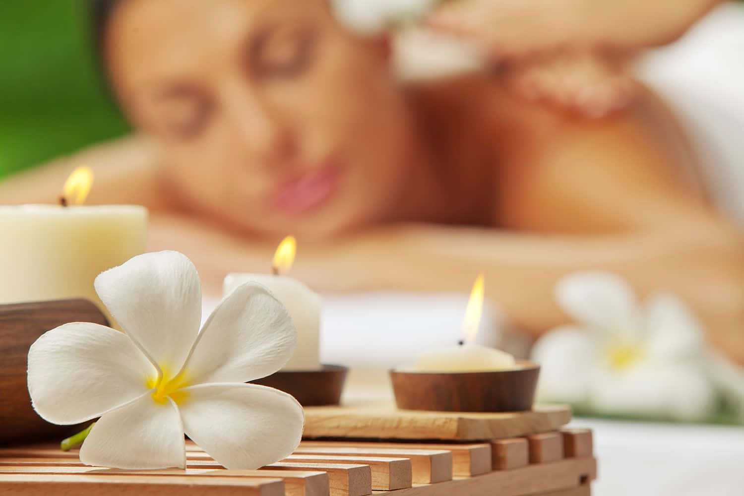 A Woman Is Getting A Massage With Flowers And Candles Wallpaper