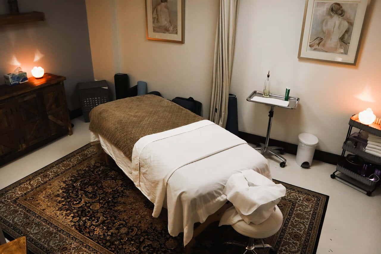 A Massage Room With A Bed And Candles
