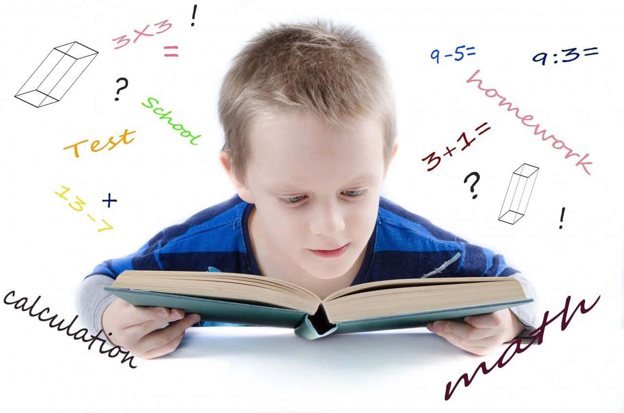 En dreng læser en bog med mange symboler omkring den.