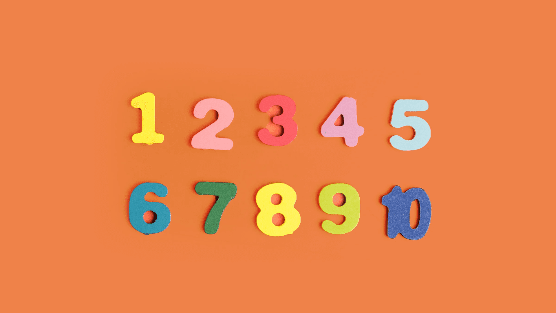 Take a closer look at the beauty of mathematics. Background — Colorful foam numbers one through ten arranged in two rows on a solid orange background.