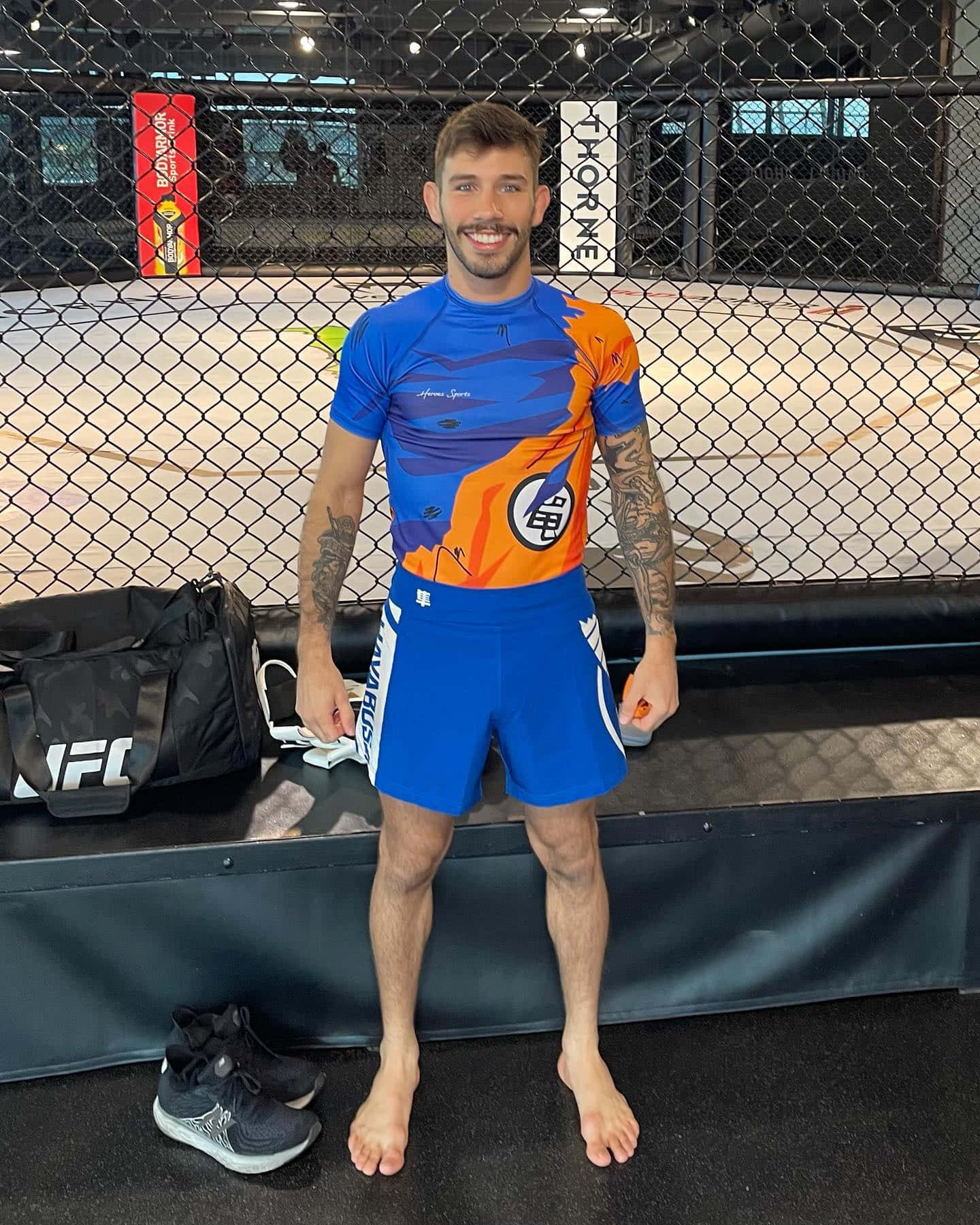 Matheus Nicolau In Orange And Blue Outfit Wallpaper