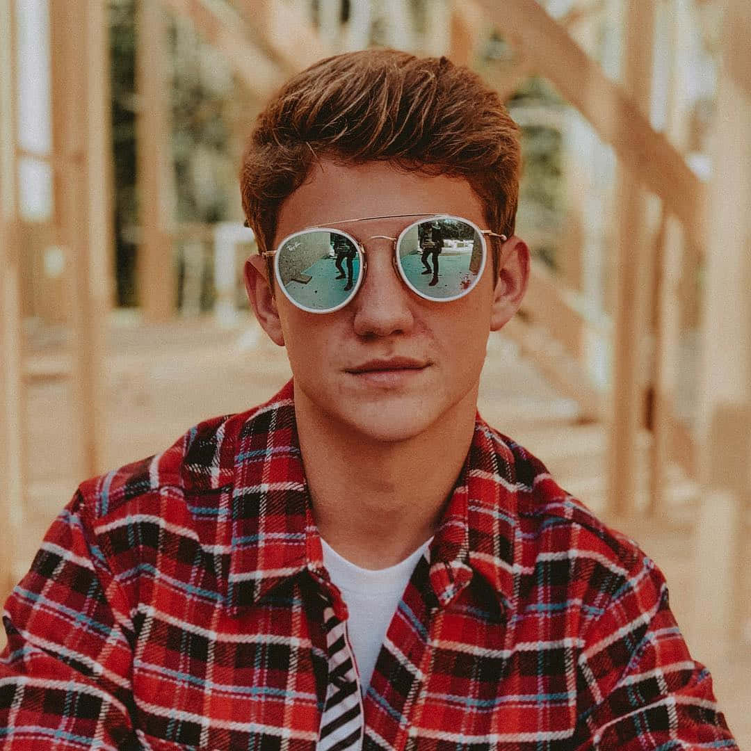 En ung mand iført solbriller og rutet skjorte Wallpaper