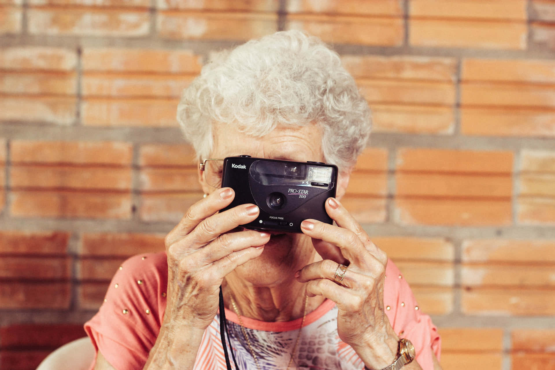 Mature Lady Shooting With Film Camera Wallpaper