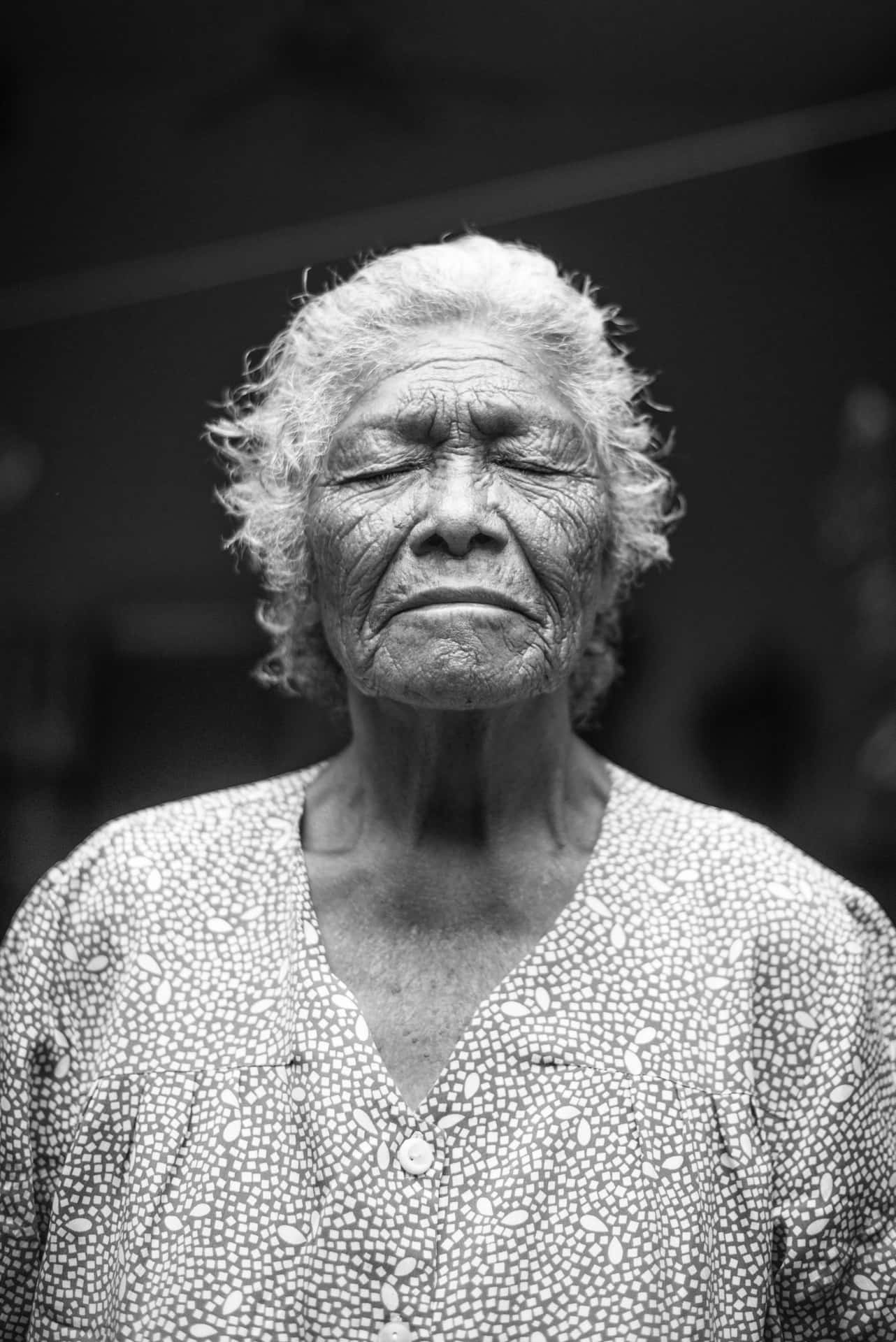 Mature Old Woman Closing Her Eyes Wallpaper