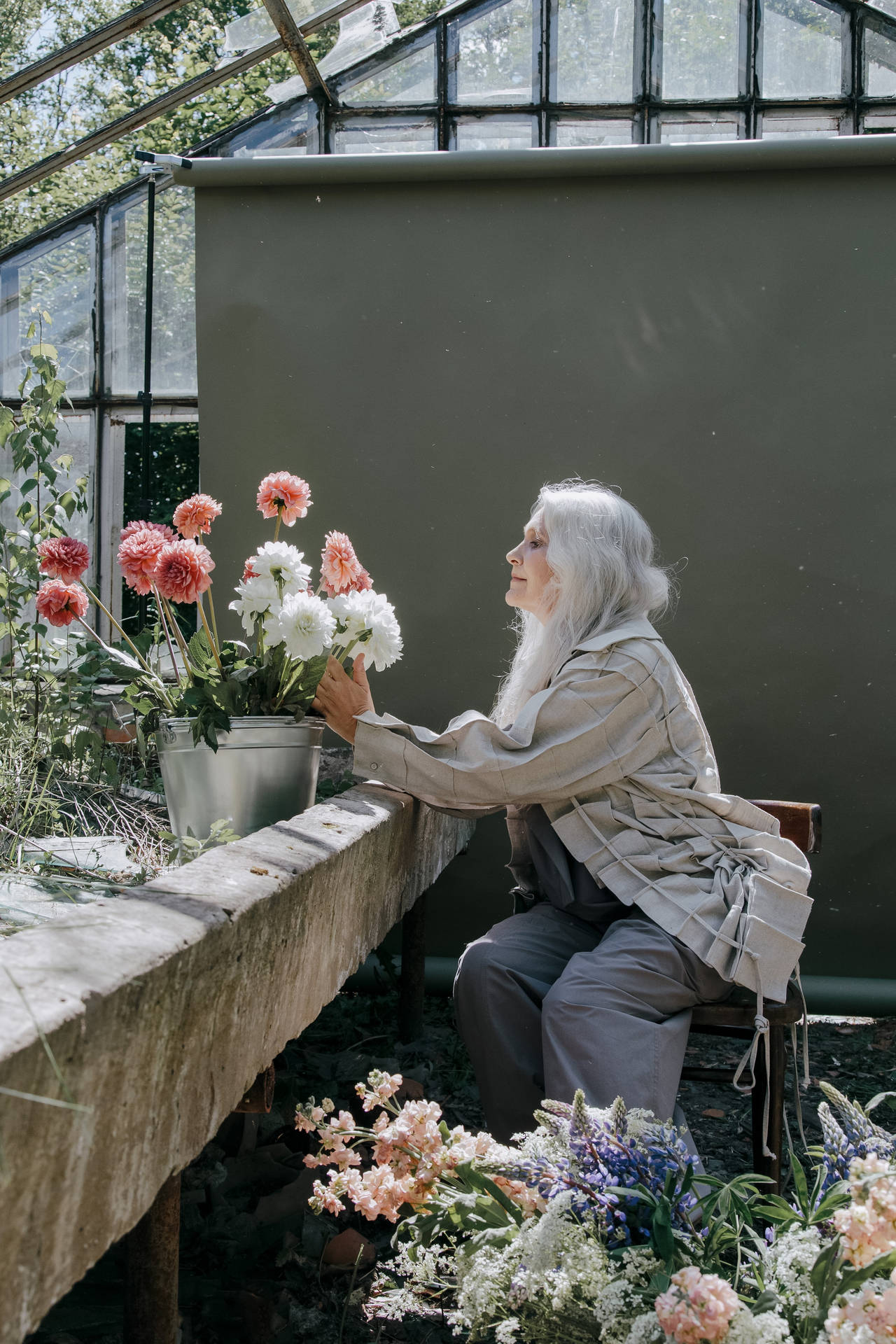 Mature Woman Arranging Flowers Wallpaper