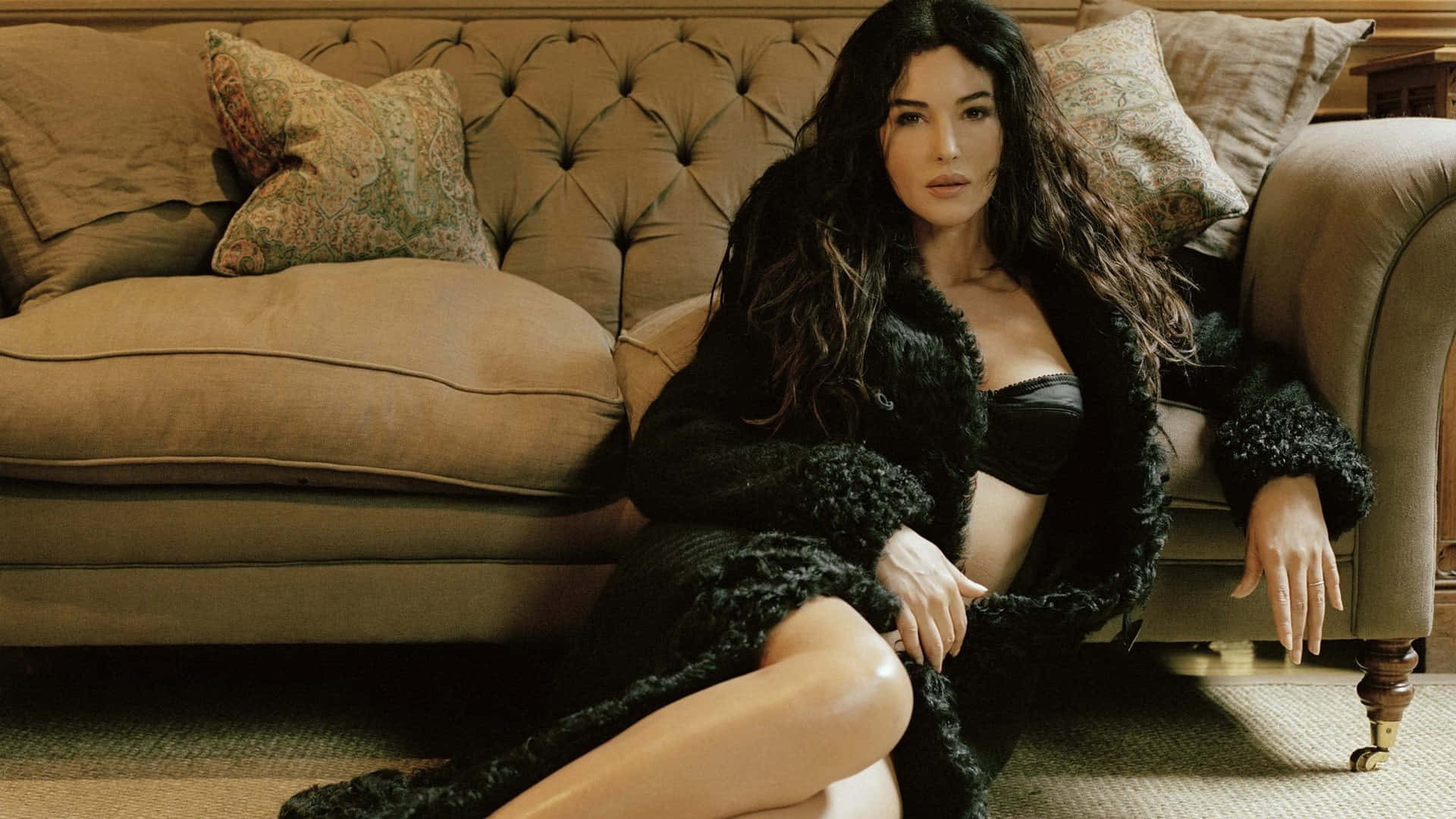 A Woman In A Black Fur Coat Sitting On A Couch
