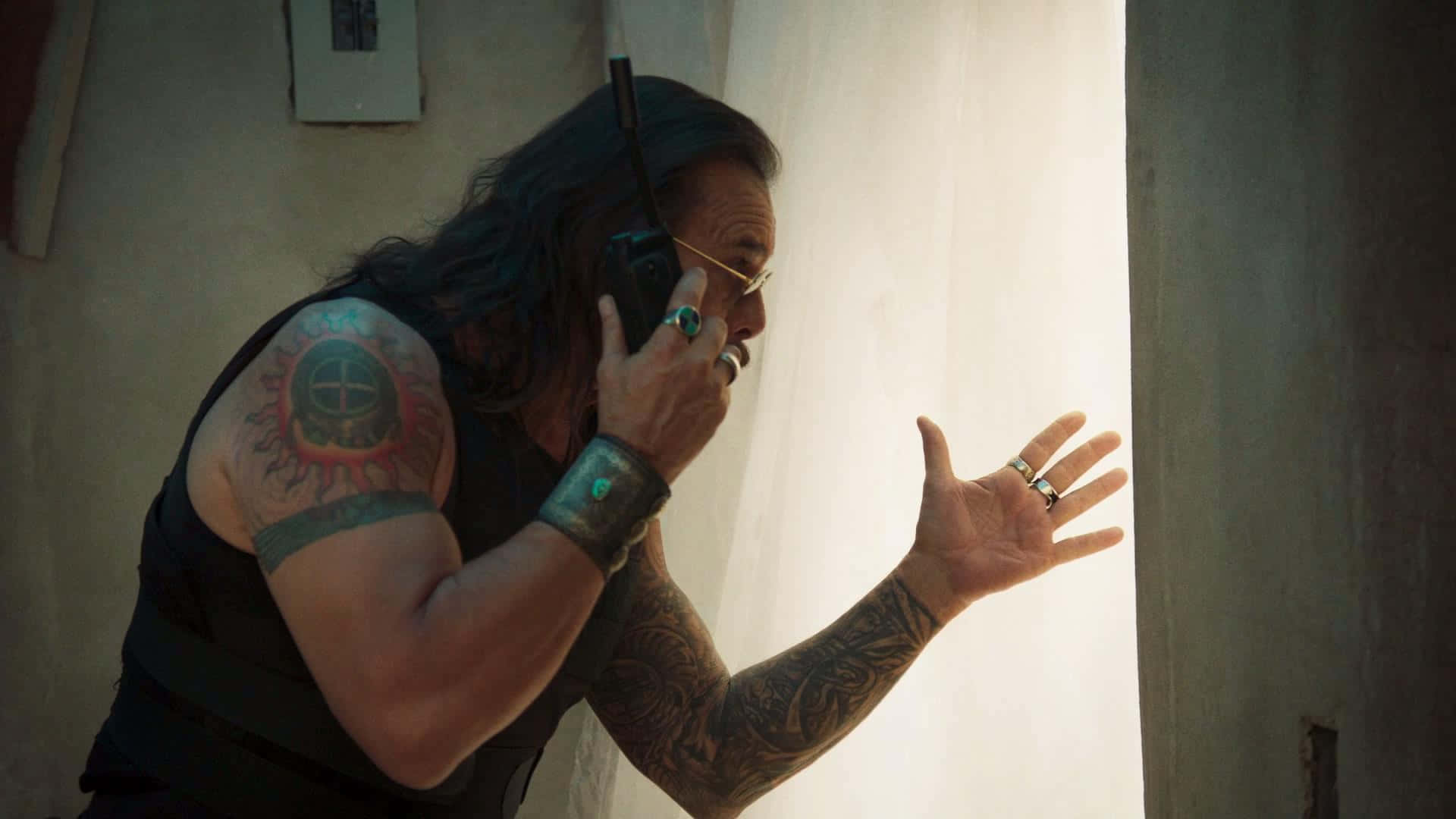 A Man With Tattoos And A Cell Phone In A Room Wallpaper