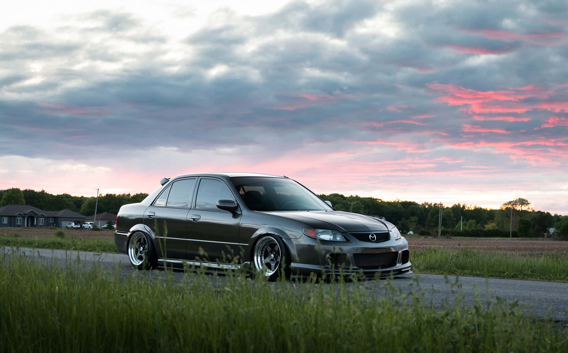 Sleek Silver Mazda Protege on the Road Wallpaper