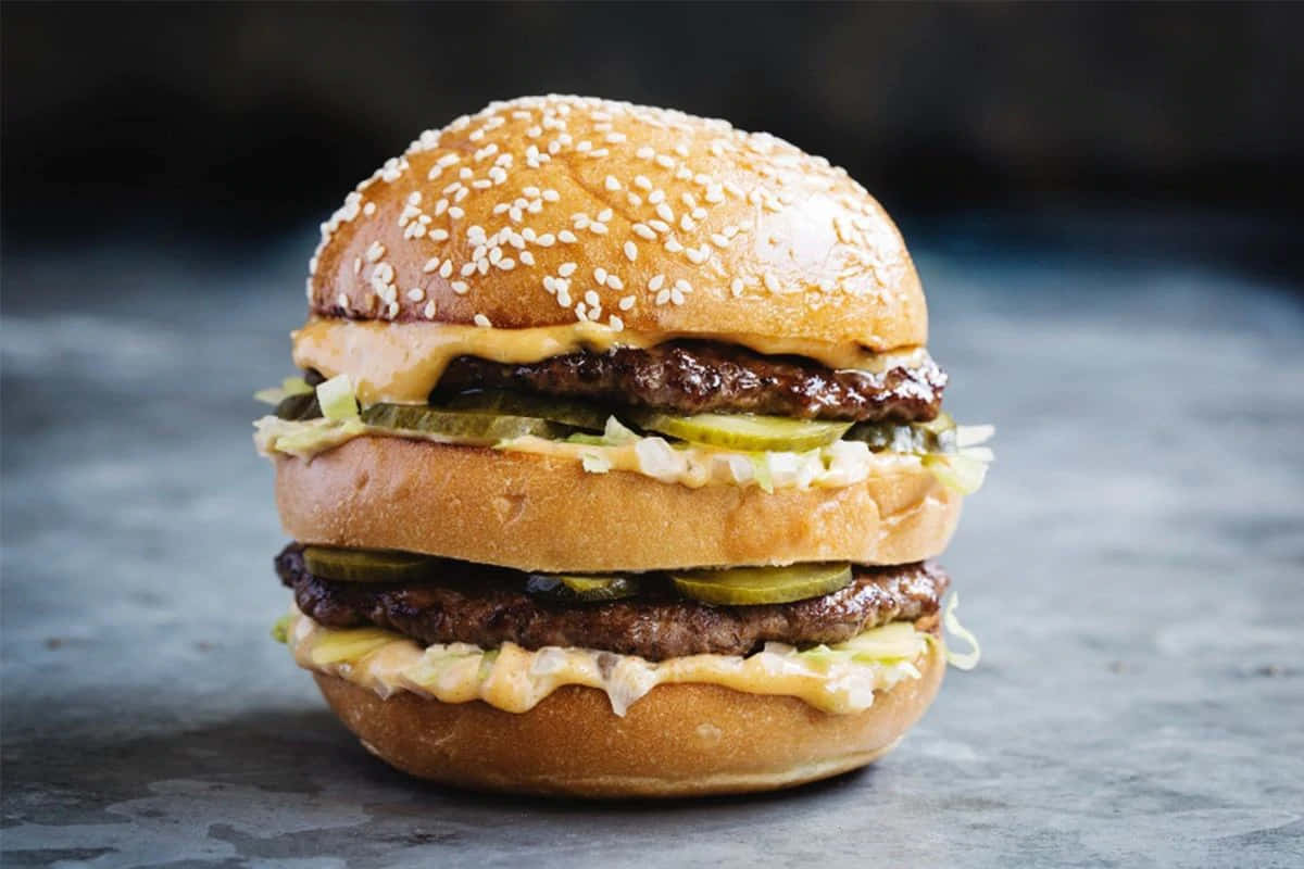 A Burger With Pickles And Mustard On Top