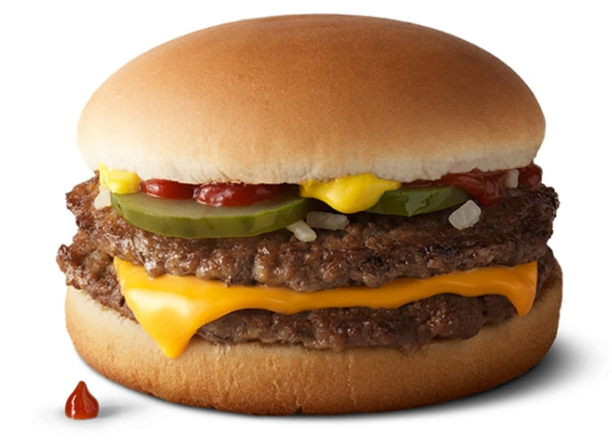 A Hamburger With Cheese And Pickles On A White Background