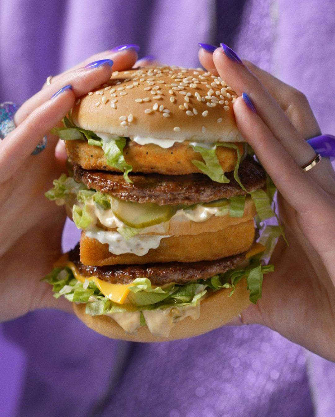 A Woman Holding A Large Purple Burger