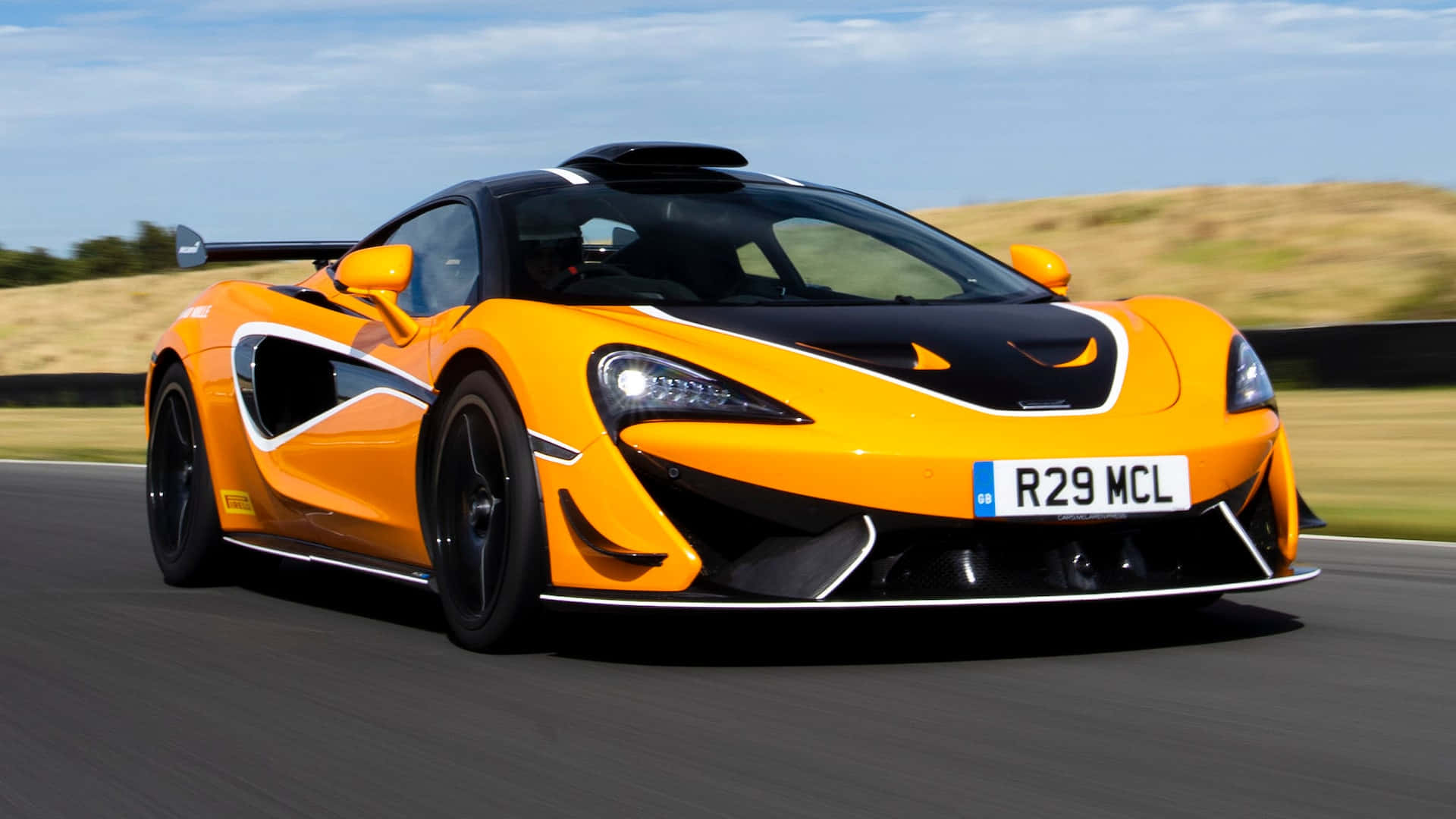 Sleek Mclaren 620R Speeding on the Open Road Wallpaper