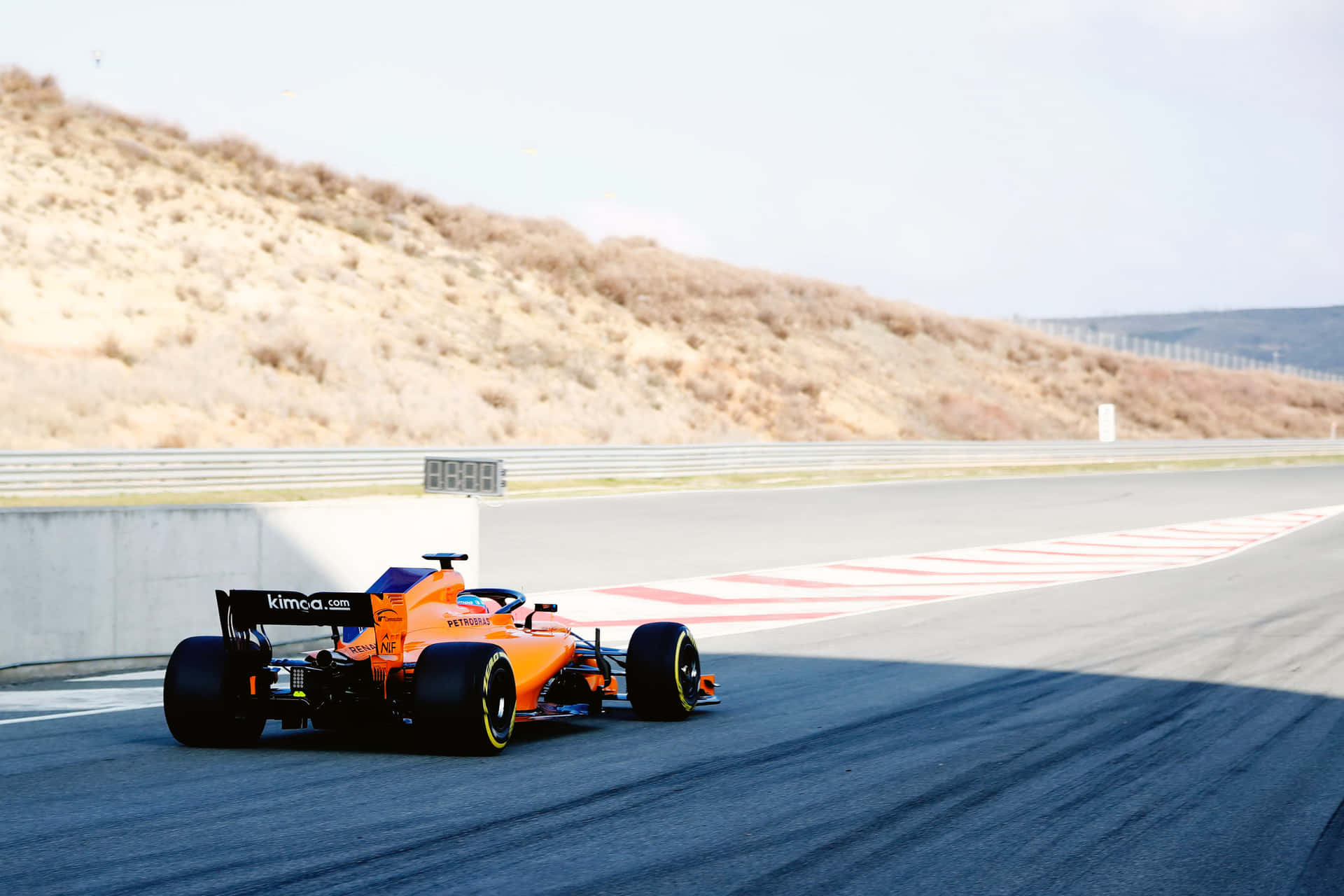 A Orange Racing Car Driving Down A Hill Wallpaper