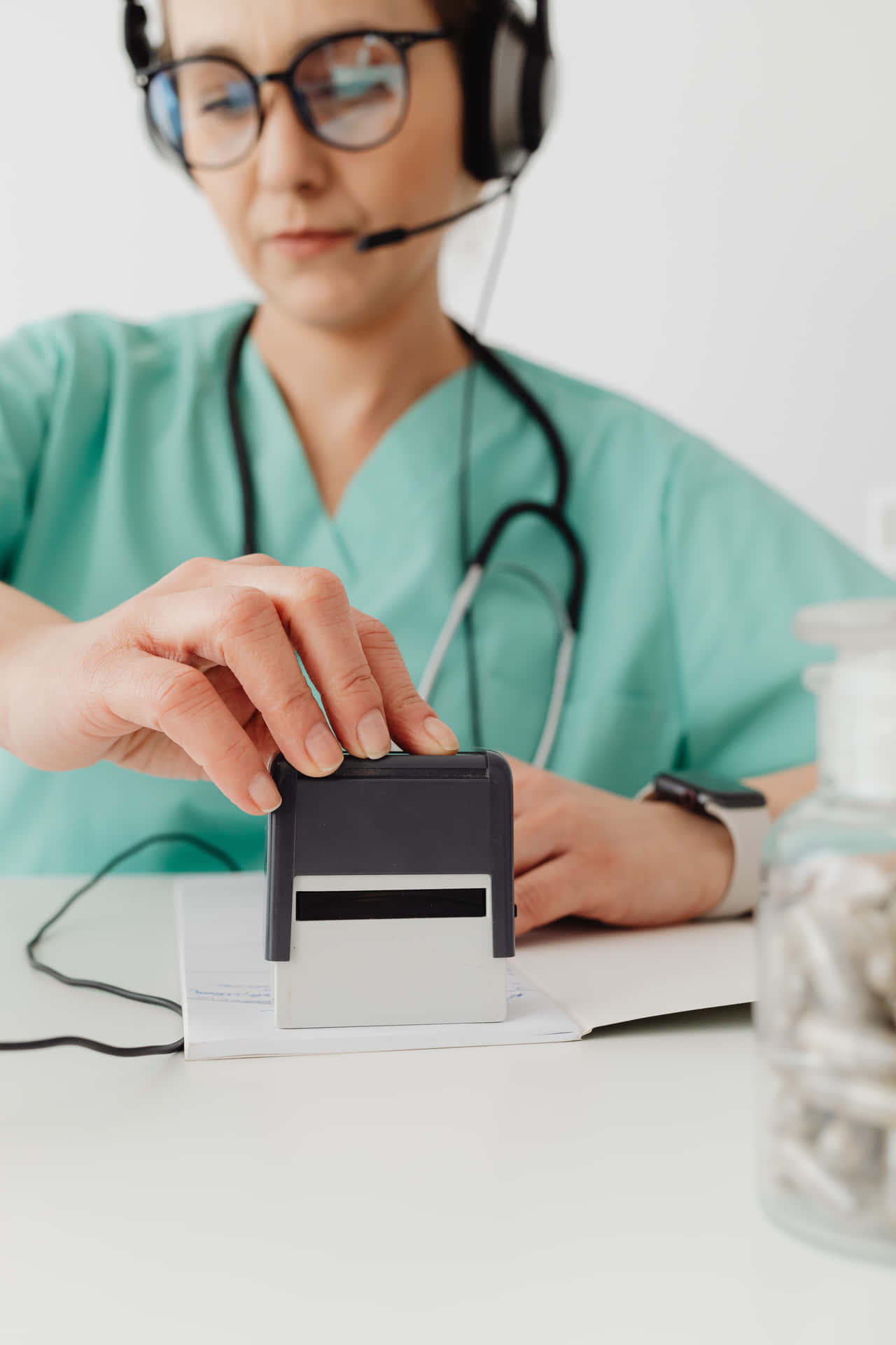 A Nurse Is Using A Stamp To Mark A Prescription