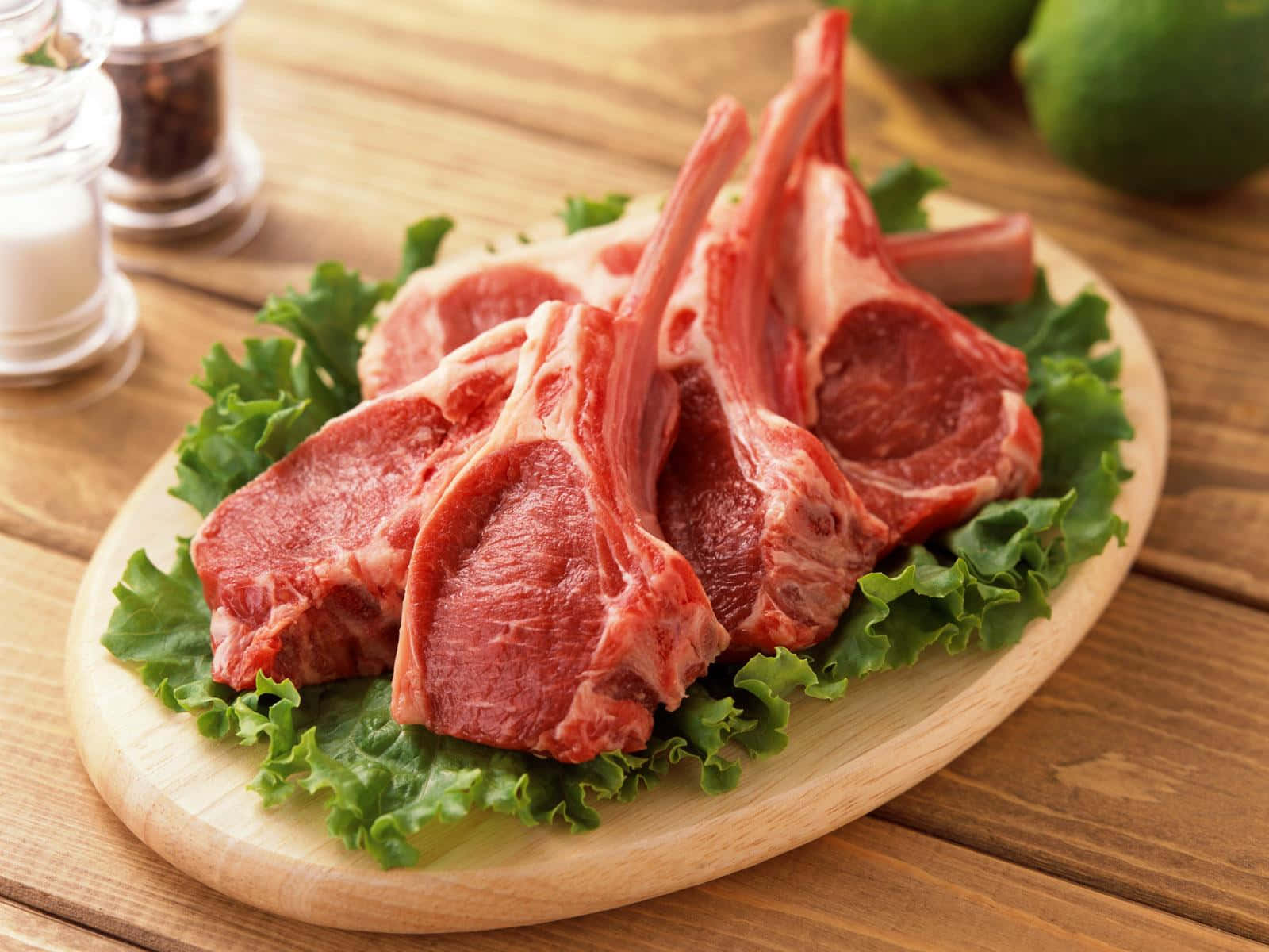 A Plate Of Lamb Chops On A Wooden Table