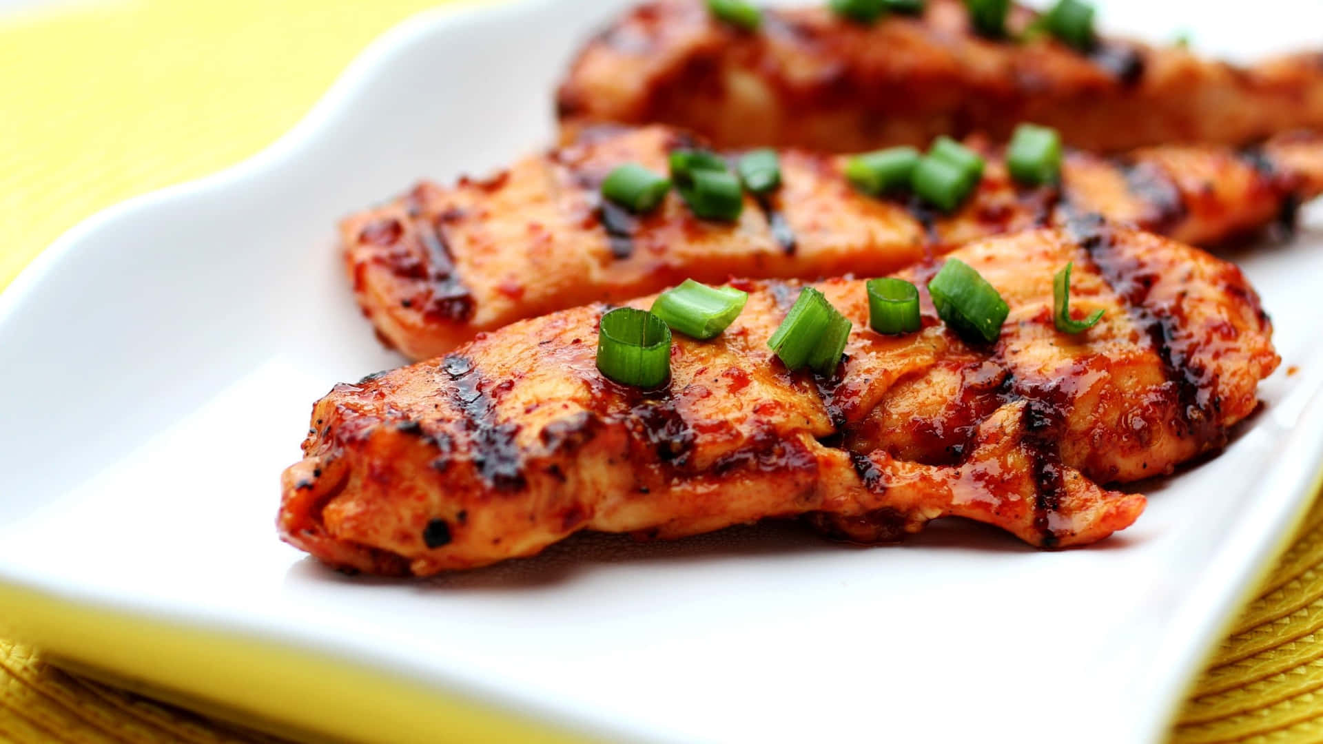 Grilled Chicken On A White Plate With Green Onions