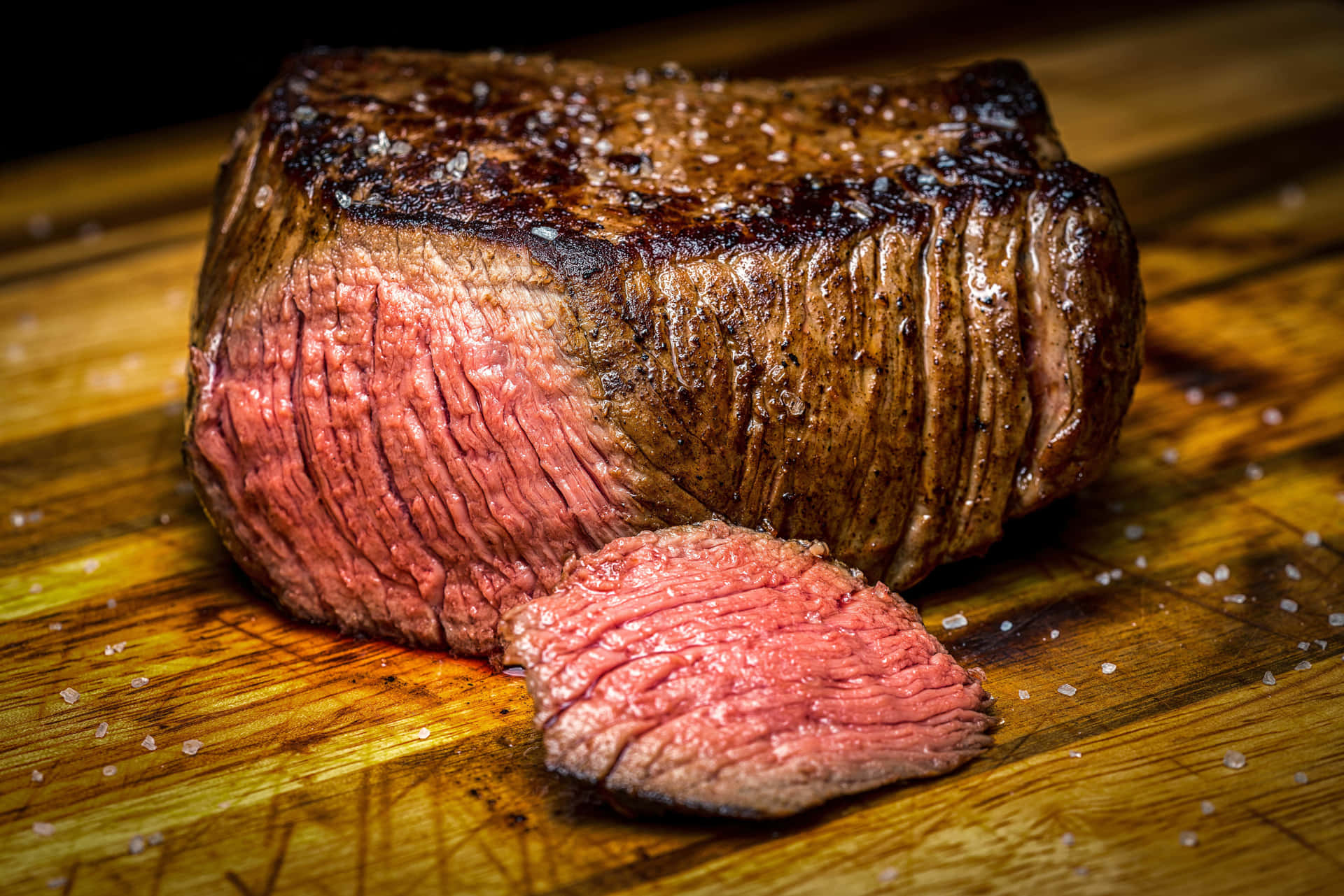 A Steak Is Sitting On A Wooden Cutting Board