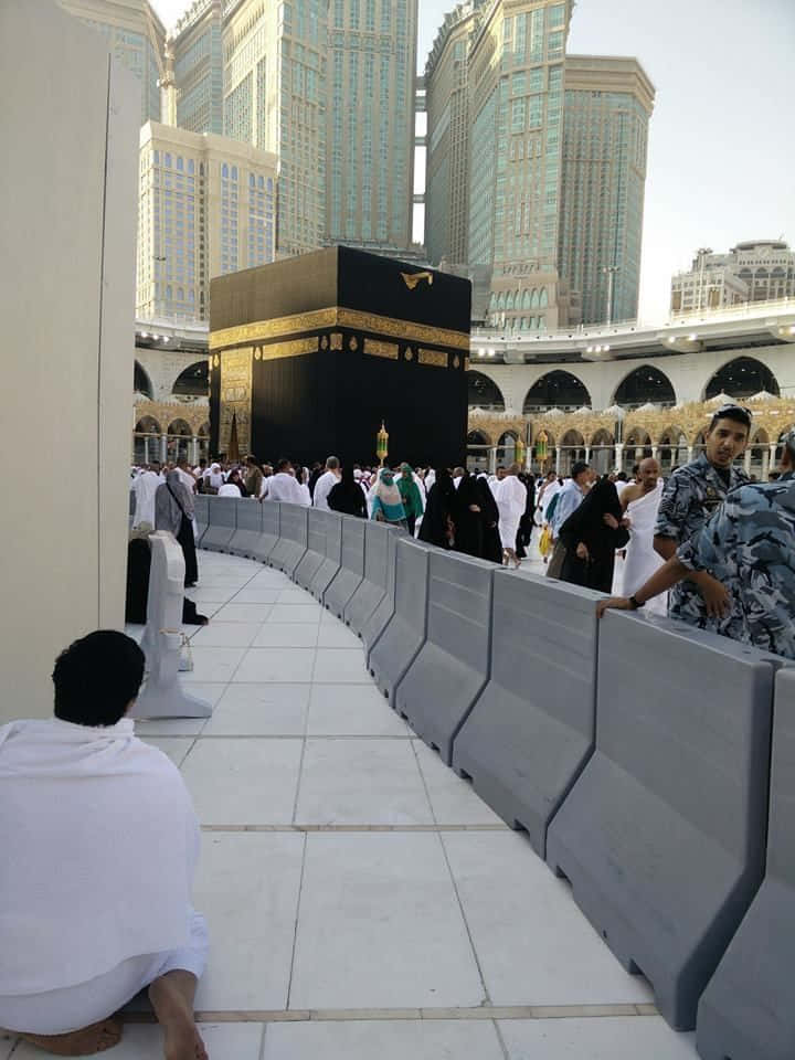 Einegruppe Von Menschen, Die Vor Der Kaaba Sitzt.