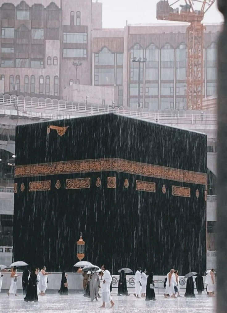People Are Standing In The Rain Near The Kaaba