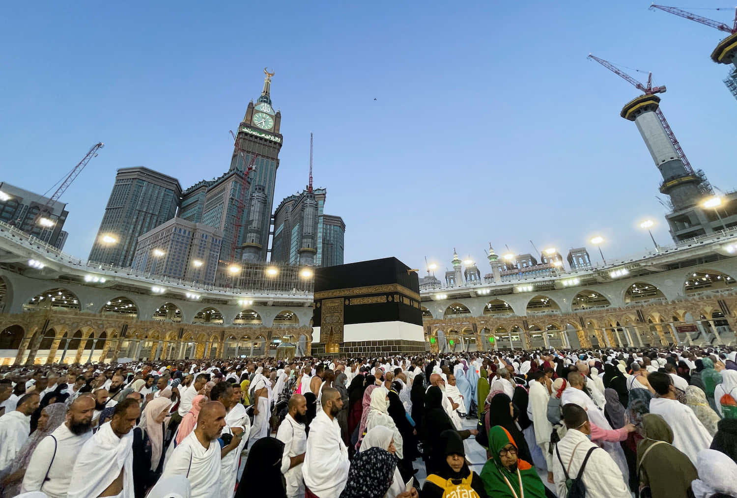 A Group Of People Are Standing In Front Of The Kaaba