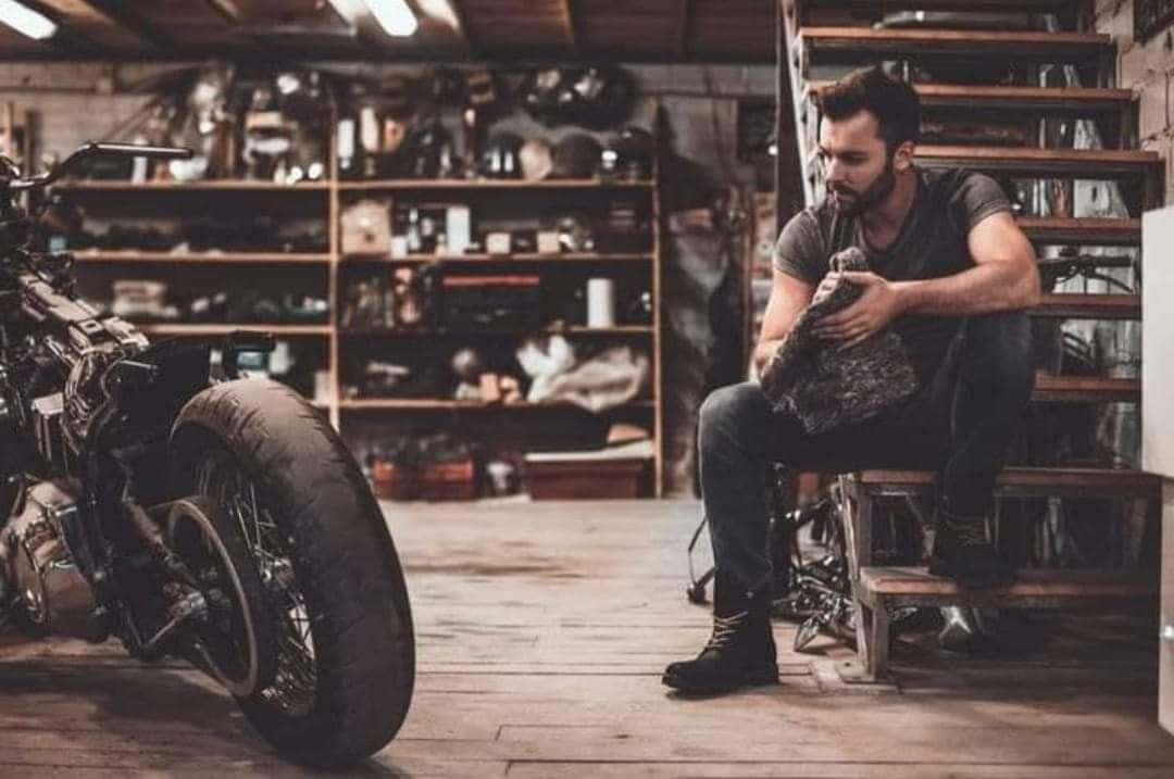 A Man Sitting On A Motorcycle In A Garage