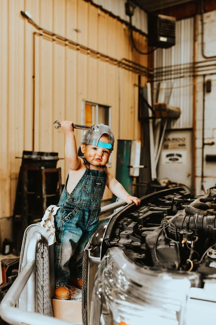 A Toddler Is Standing On Top Of A Car Engine