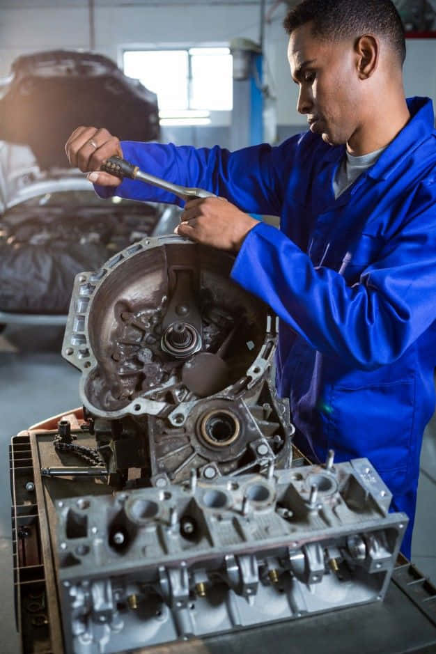 A Mechanic Working On A Car Engine