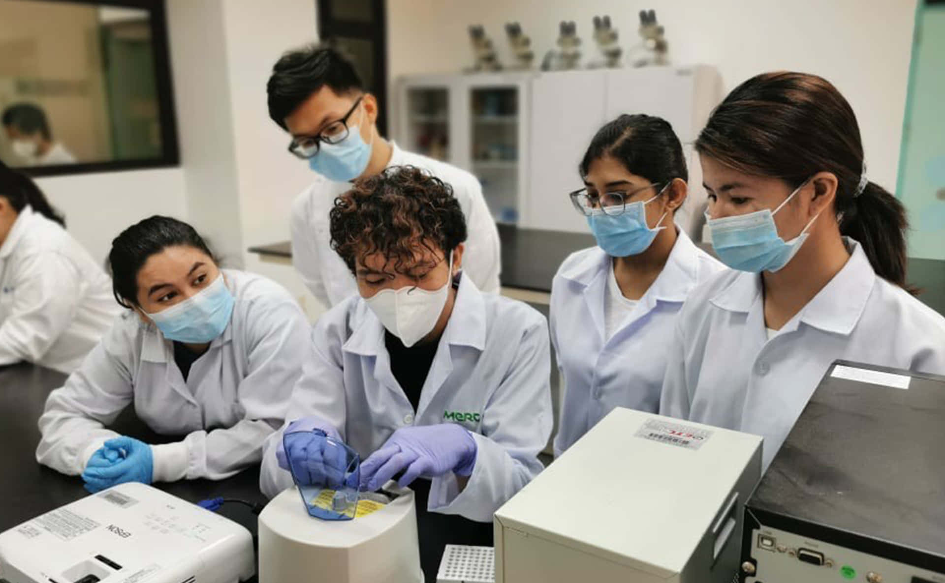 Students In Lab Coats Working On A Project