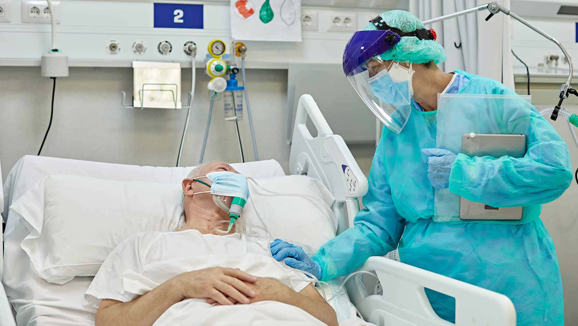 Enkvinde Med En Blå Maske Ligger I En Hospitals Seng.