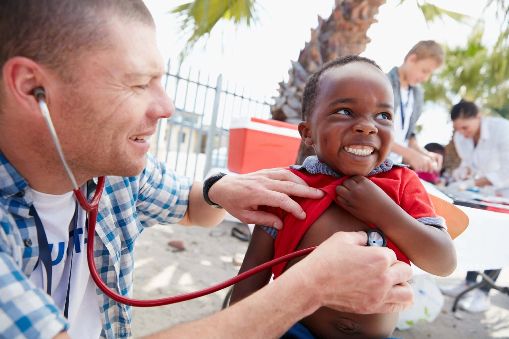 A Man Is Examining A Child With A Stethoscope