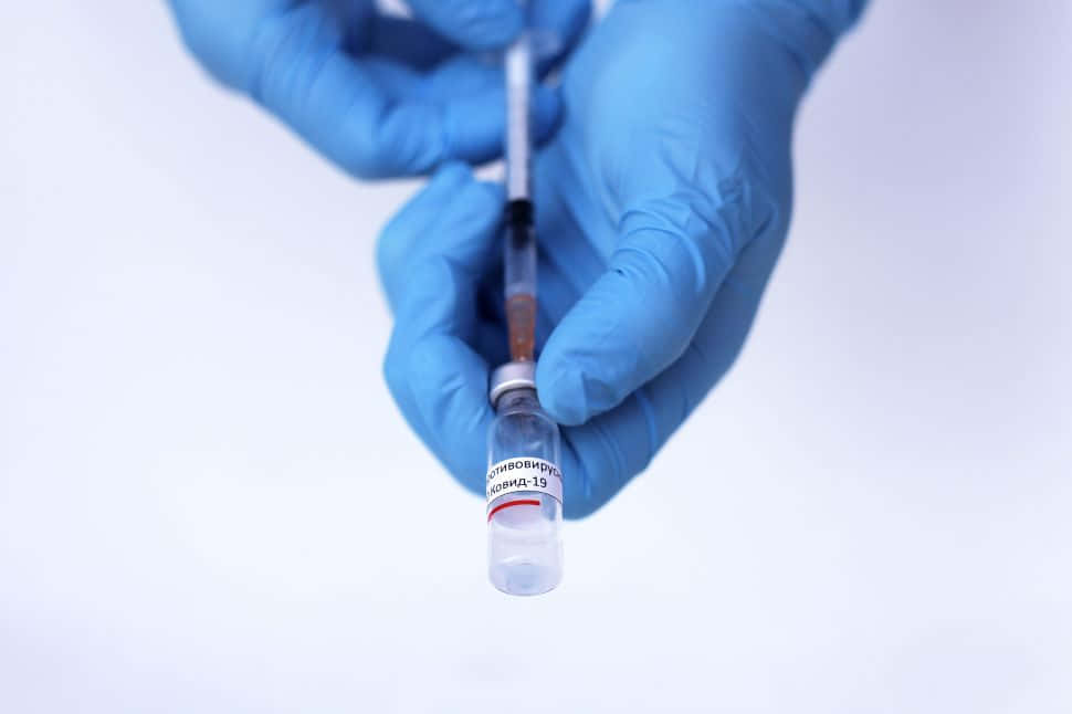 Sjukvårdsarbetaresätter In Covid-19 Vaccinampull På Datorskärmsbakgrund Eller Mobilbakgrund. Wallpaper