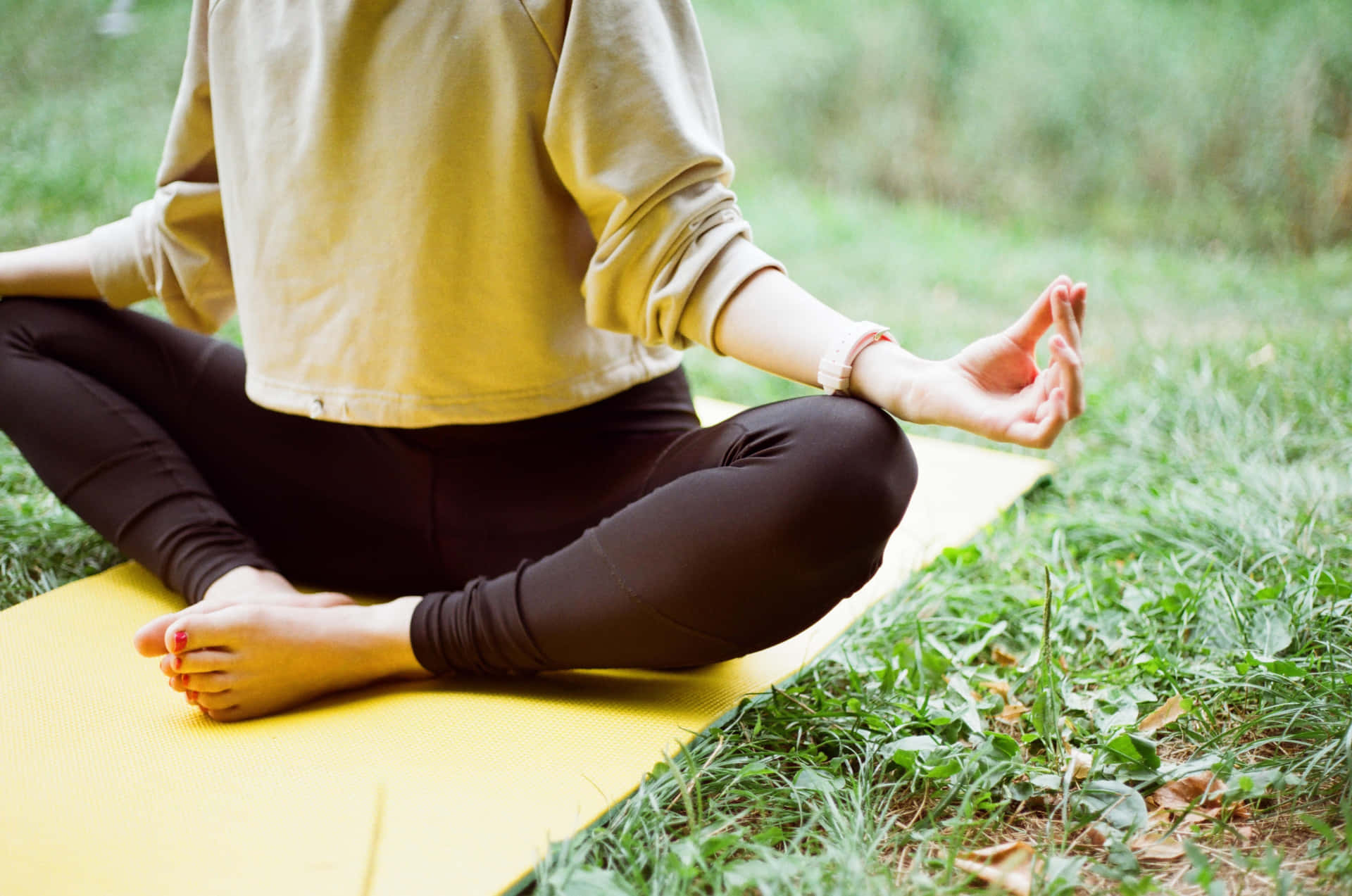 A Woman Is Sitting On A Yellow Mat Doing Yoga Wallpaper