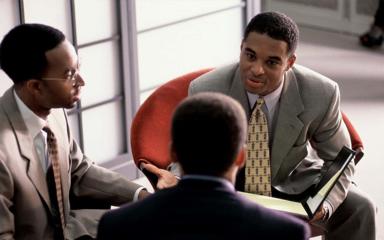 Three Men In Suits Sitting In A Meeting