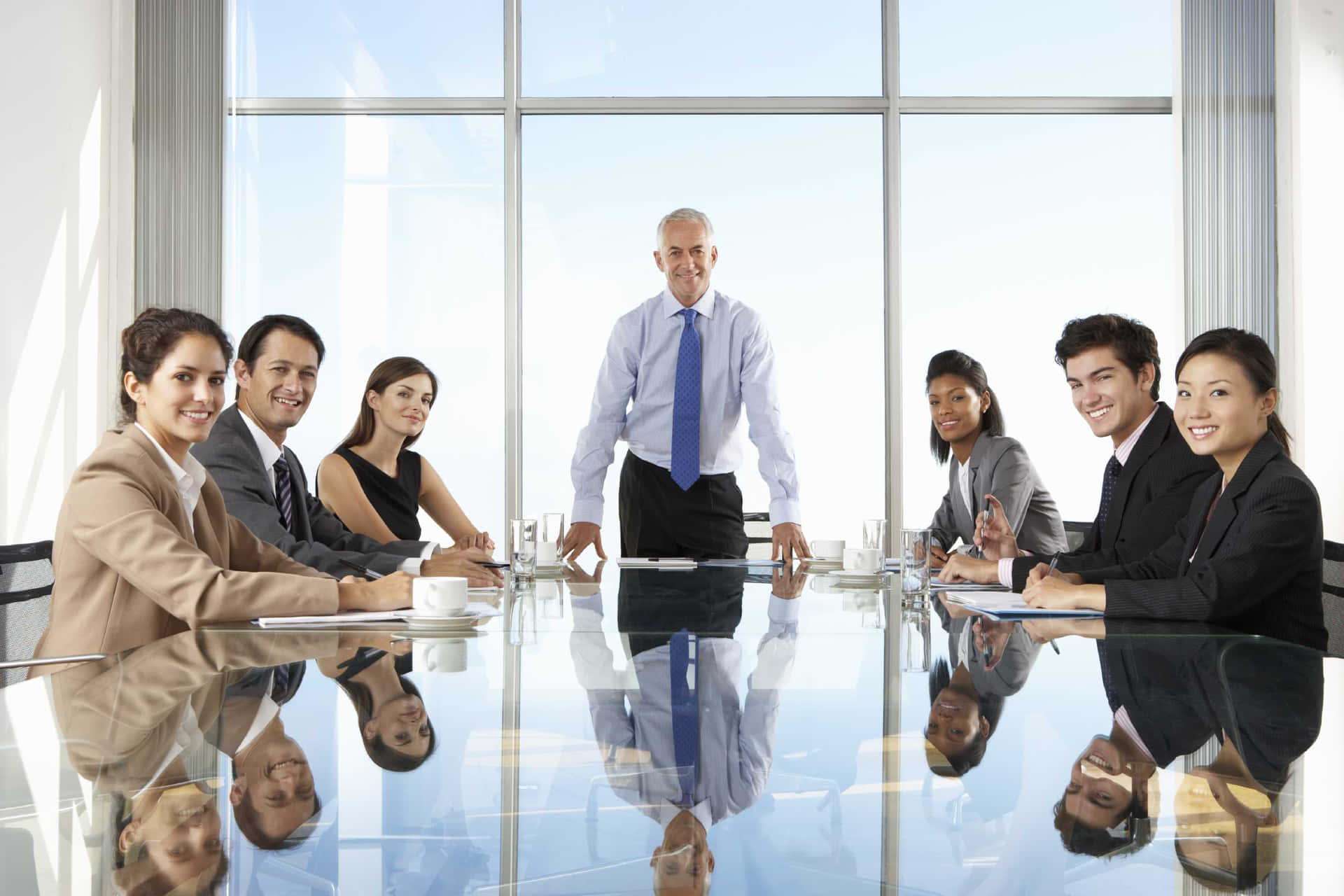 A Group Of Business People Sitting Around A Conference Table