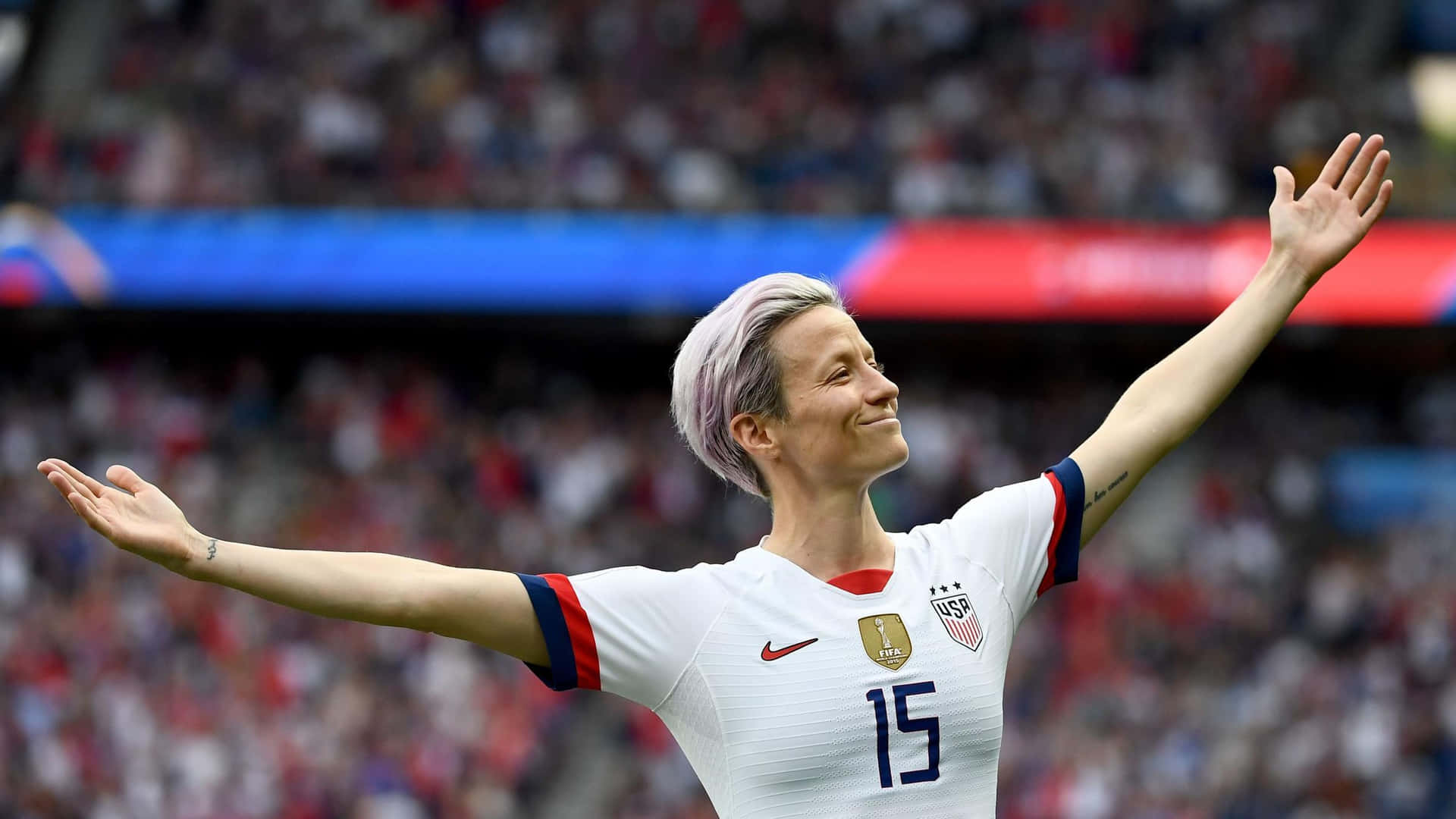 Megan Rapinoe In Action During A Soccer Game Wallpaper