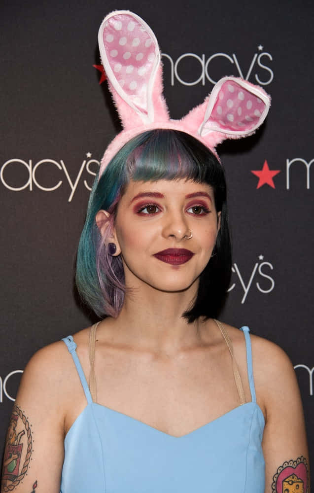 Melanie Martinez posing in her colorful, whimsical world