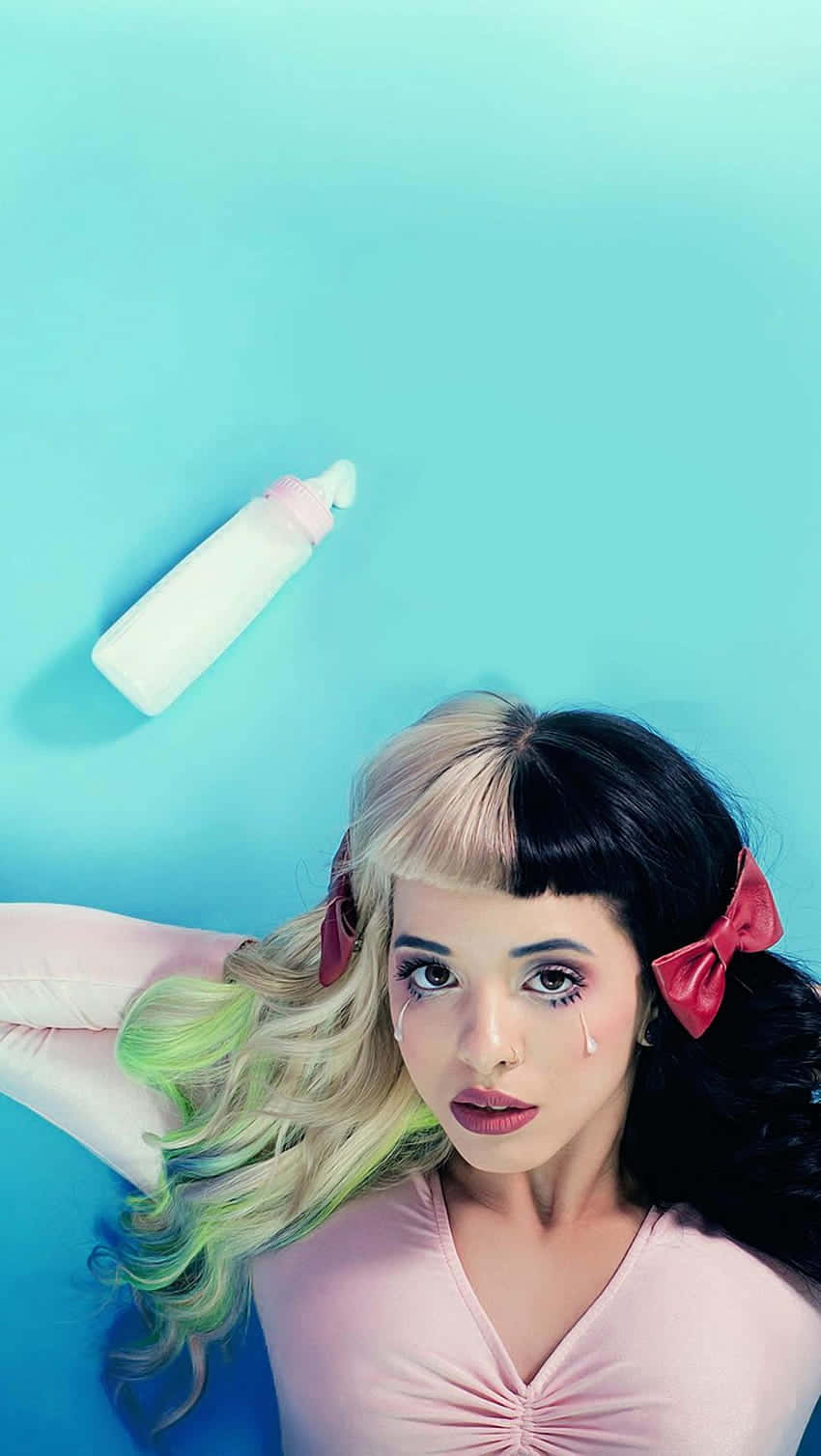 Melanie Martinez striking a pose in a whimsical, pastel-themed room