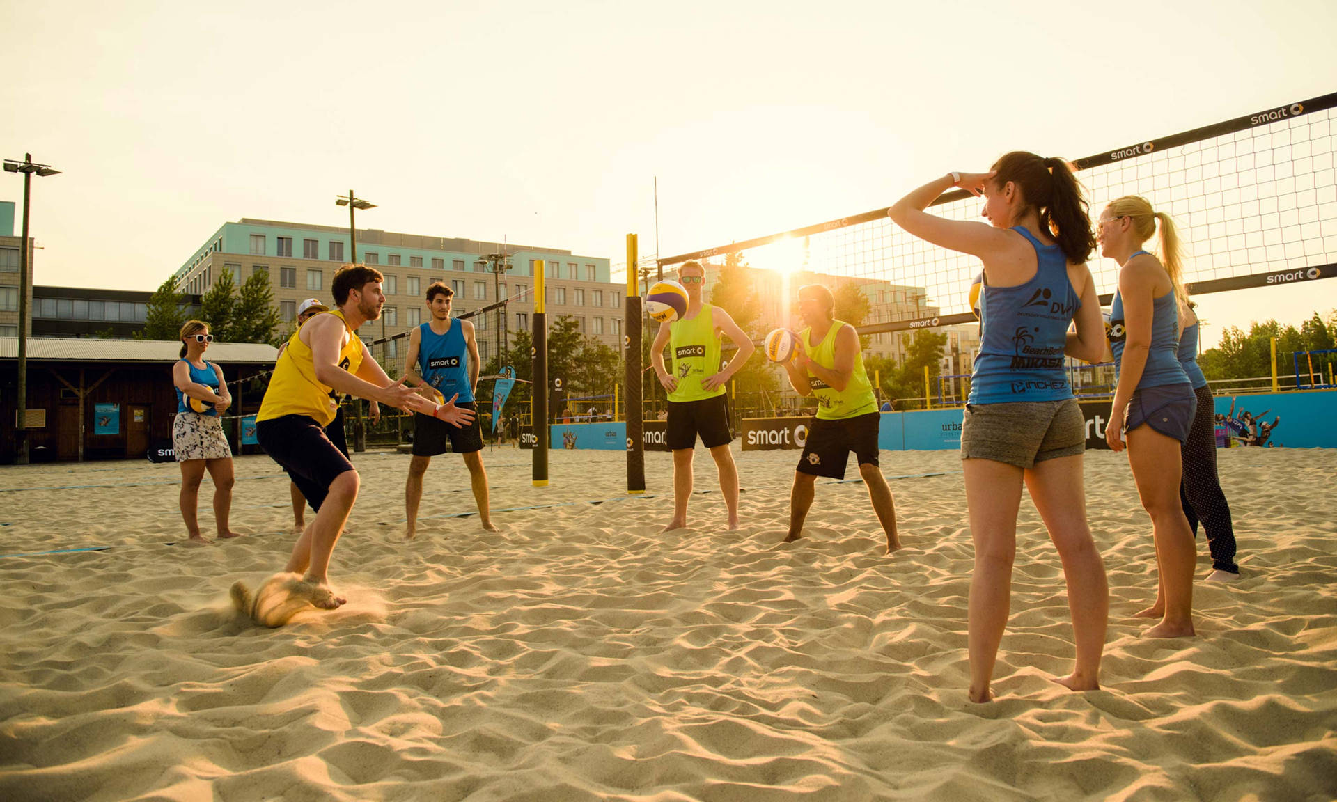 Kvinder og mænd, der spiller strand volleyball Wallpaper