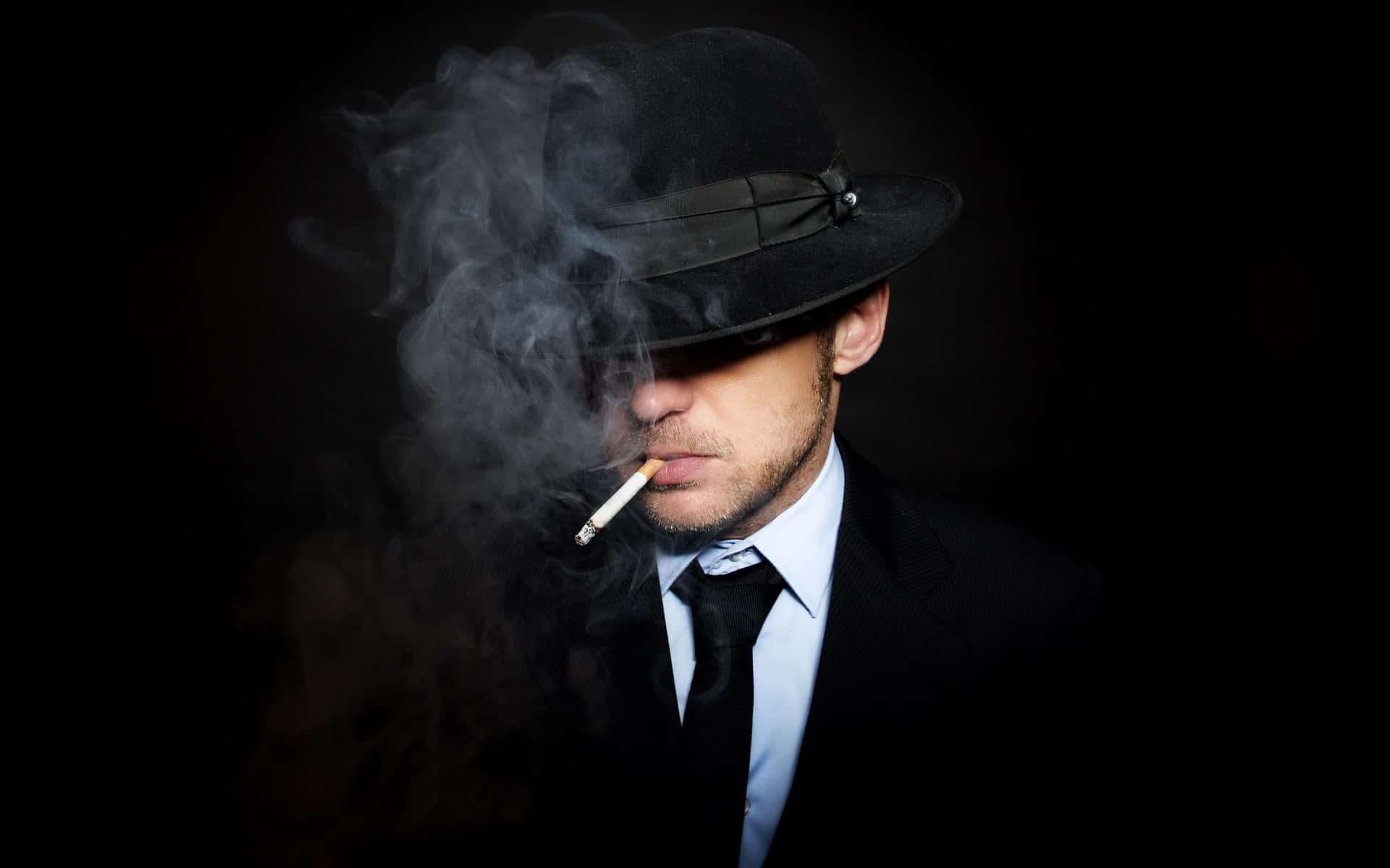 A Man In A Hat Smoking A Cigarette